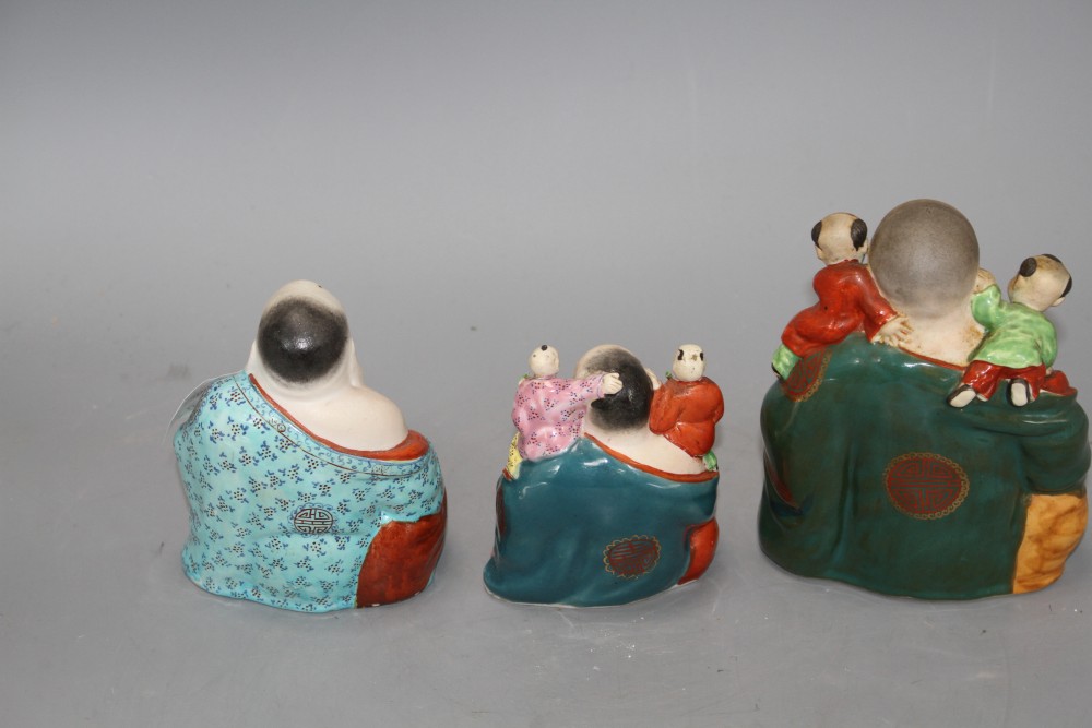 Three Chinese famille rose groups of Budai, mid 20th century, two modelled with children and with impressed makers marks, 10cm - 15cm